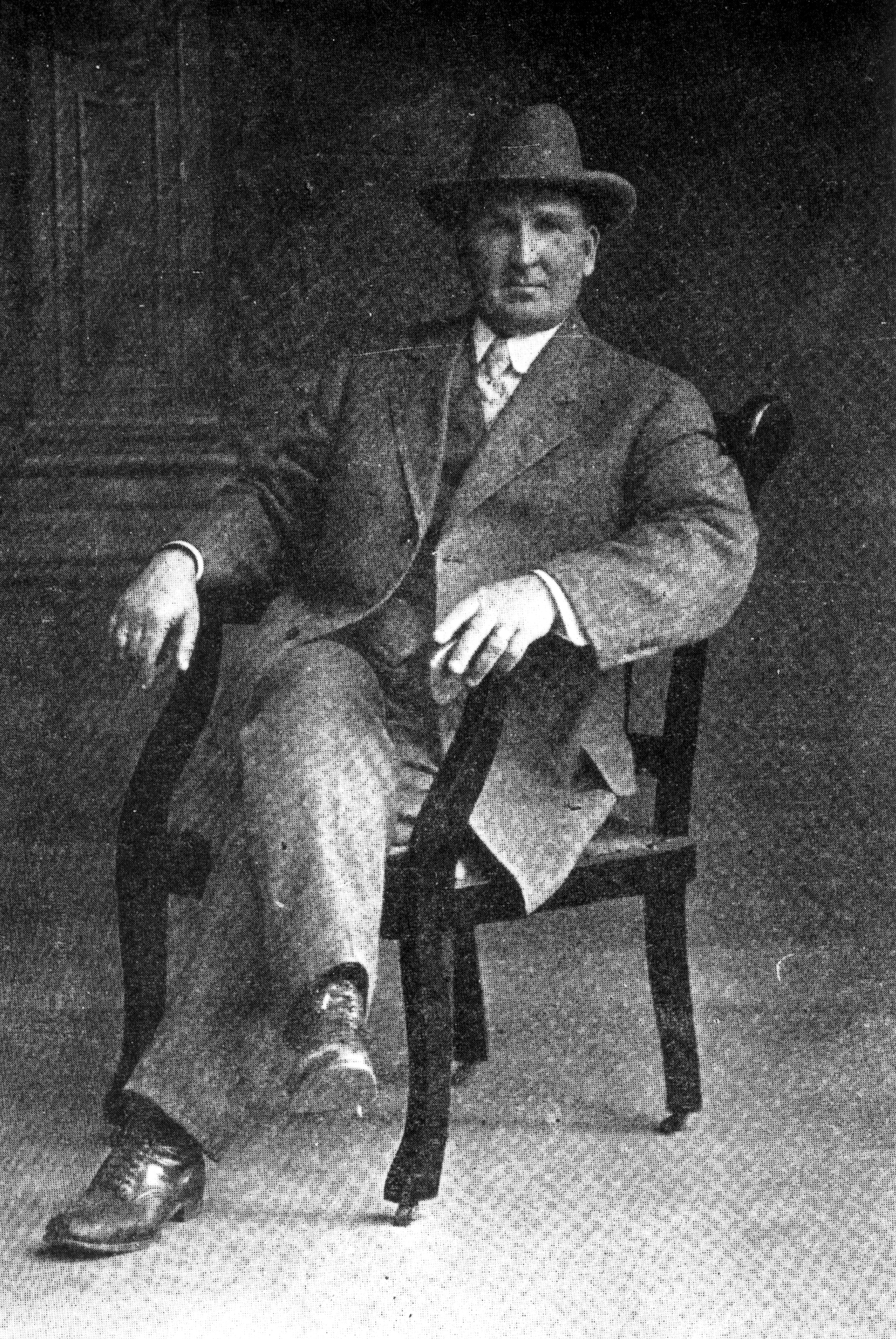 A black and white photograph of Charles Ruddock seated on a chair.