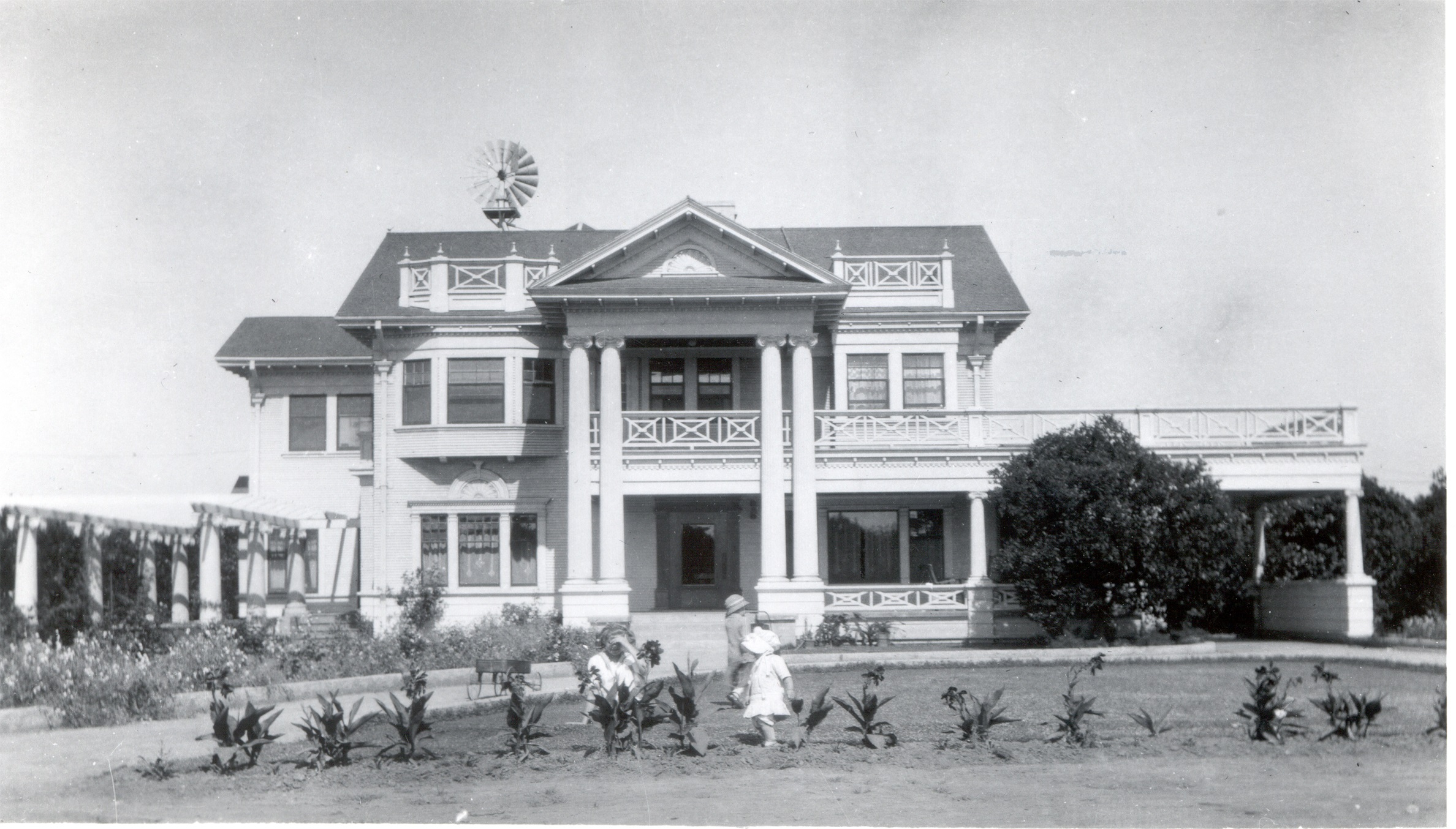 A black and white photograph of the Pierotti family outside the front of the Pierotti House &amp; Gardens in 1909.