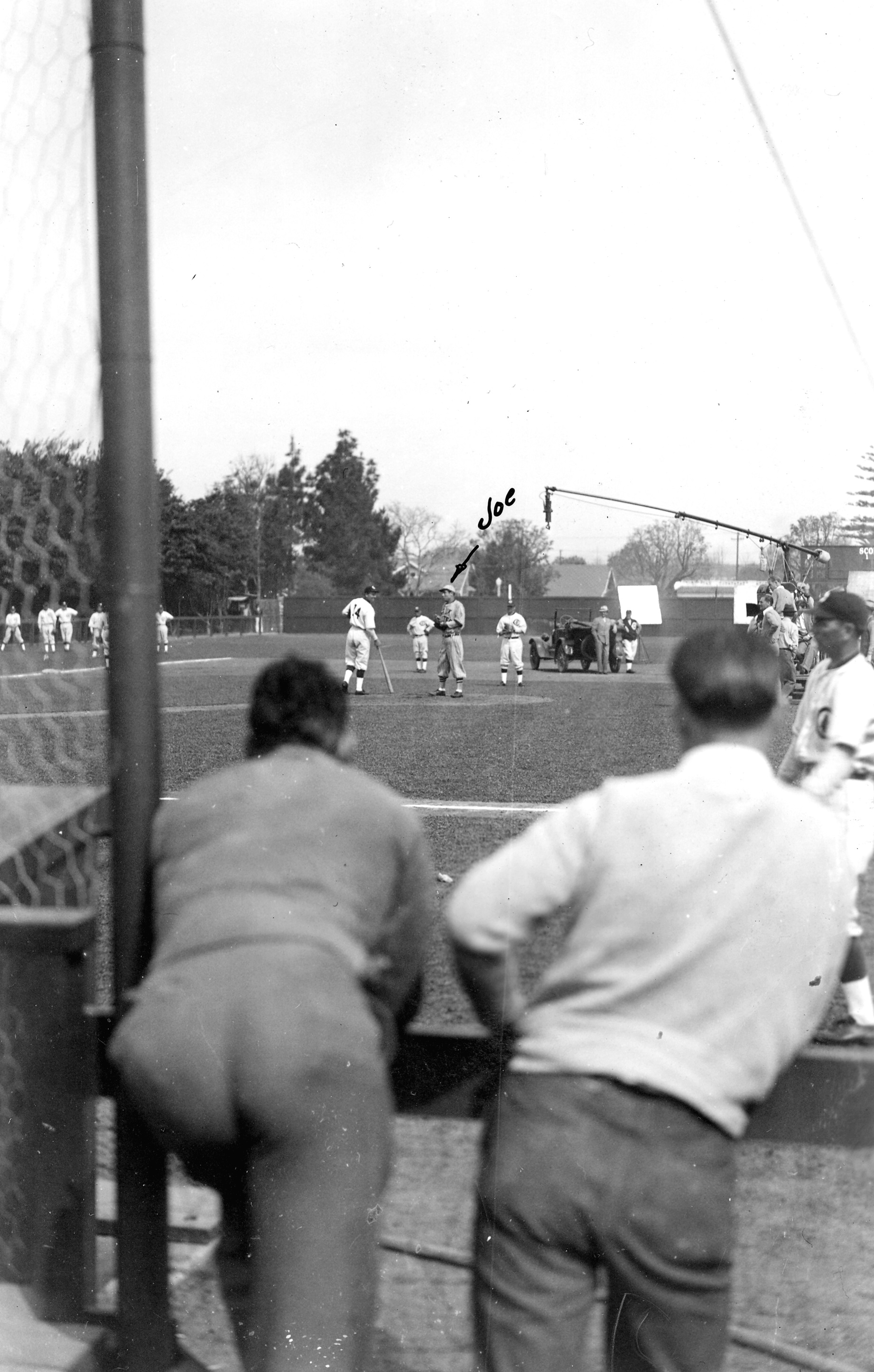 A black and white photograph of the filming of Alibi Ike in 1935 at Amerige Park. &quot;Joe&quot; is written in the middle of the photo, with an arrow pointing at the center right player standing in the photo.