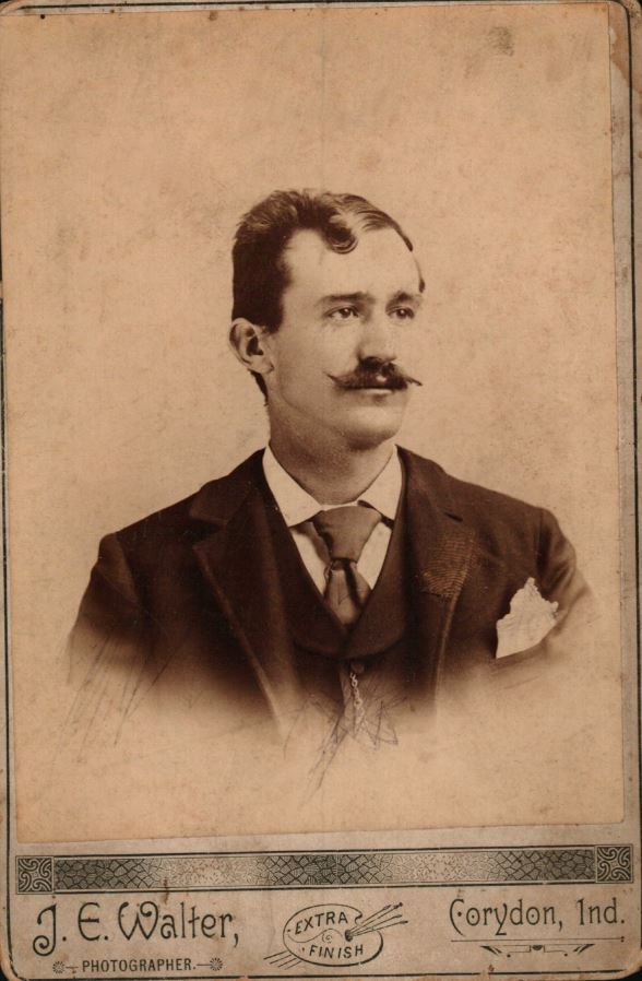 A vintage portrait photograph of James Glenn. The bottom of the photo contains a logo of Extra Finish and reads: J.E. Walter, Photographer. Corydon, Ind.