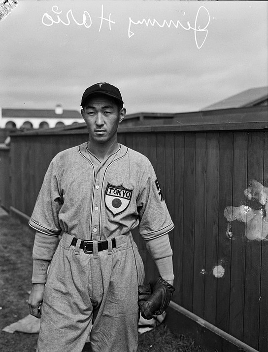A black and white photograph of Jimmy Horio standing along a wooden fence at Amerige Park in 1935. The top of the photo, written in reverse and in cursive, reads: Jimmy Horio.