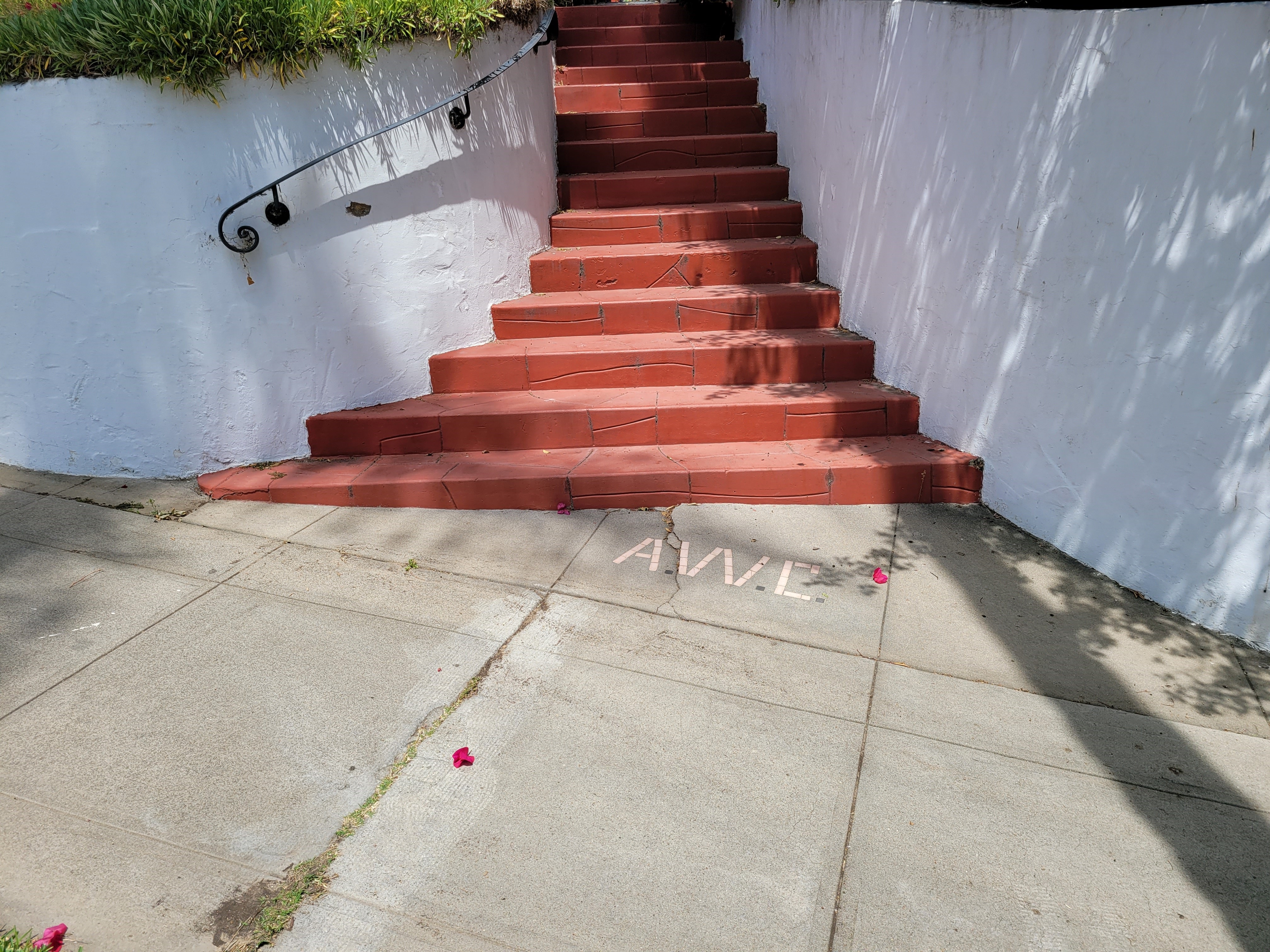 A colored photo of Cleaver&#039;s initials in the sidewalk in front of the Arthur Cleaver House in 2021.