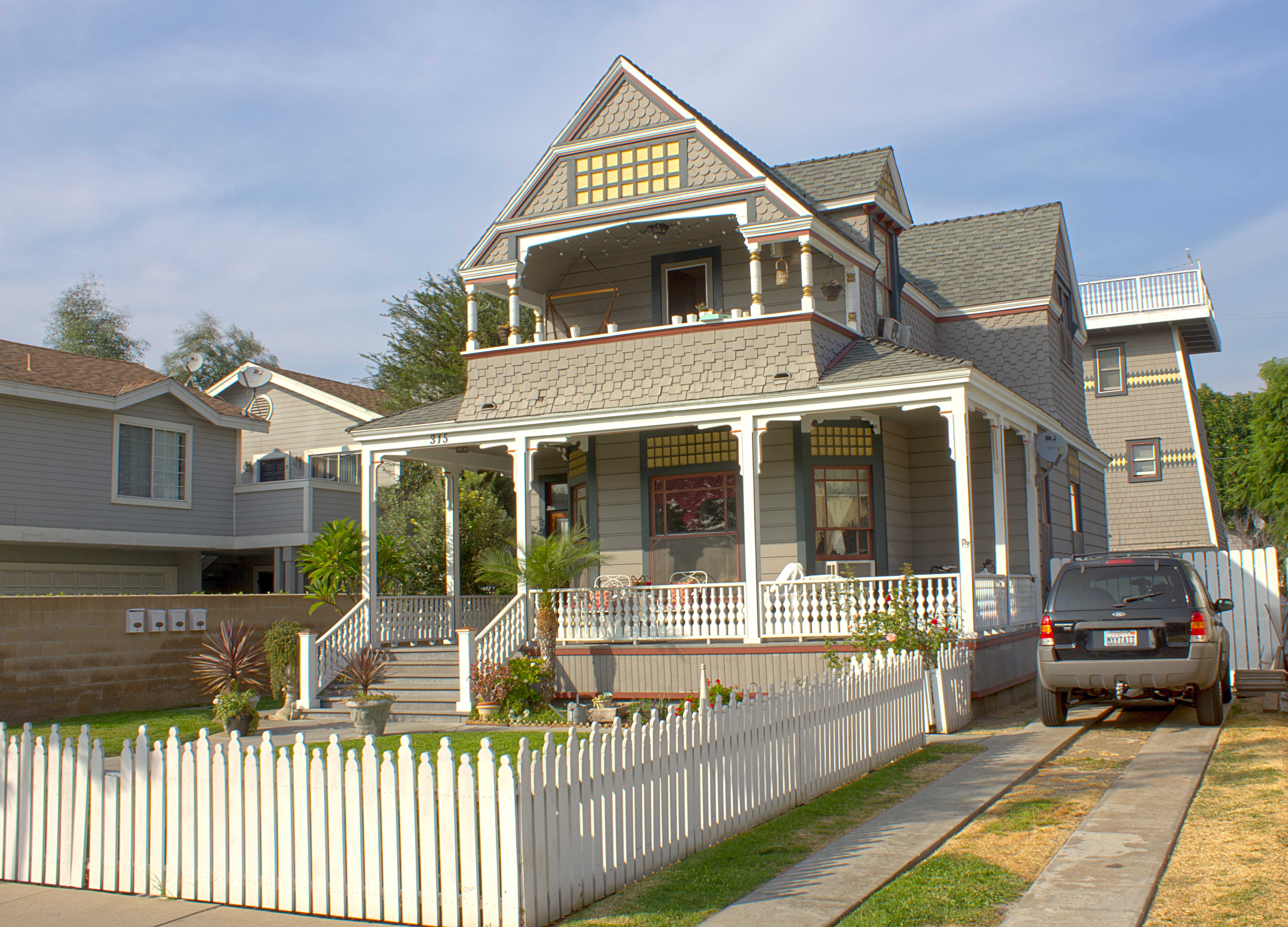 A colored photo of the Wilshire Brothers/Cusick House&#039;s exterior with a water tower in 2012.