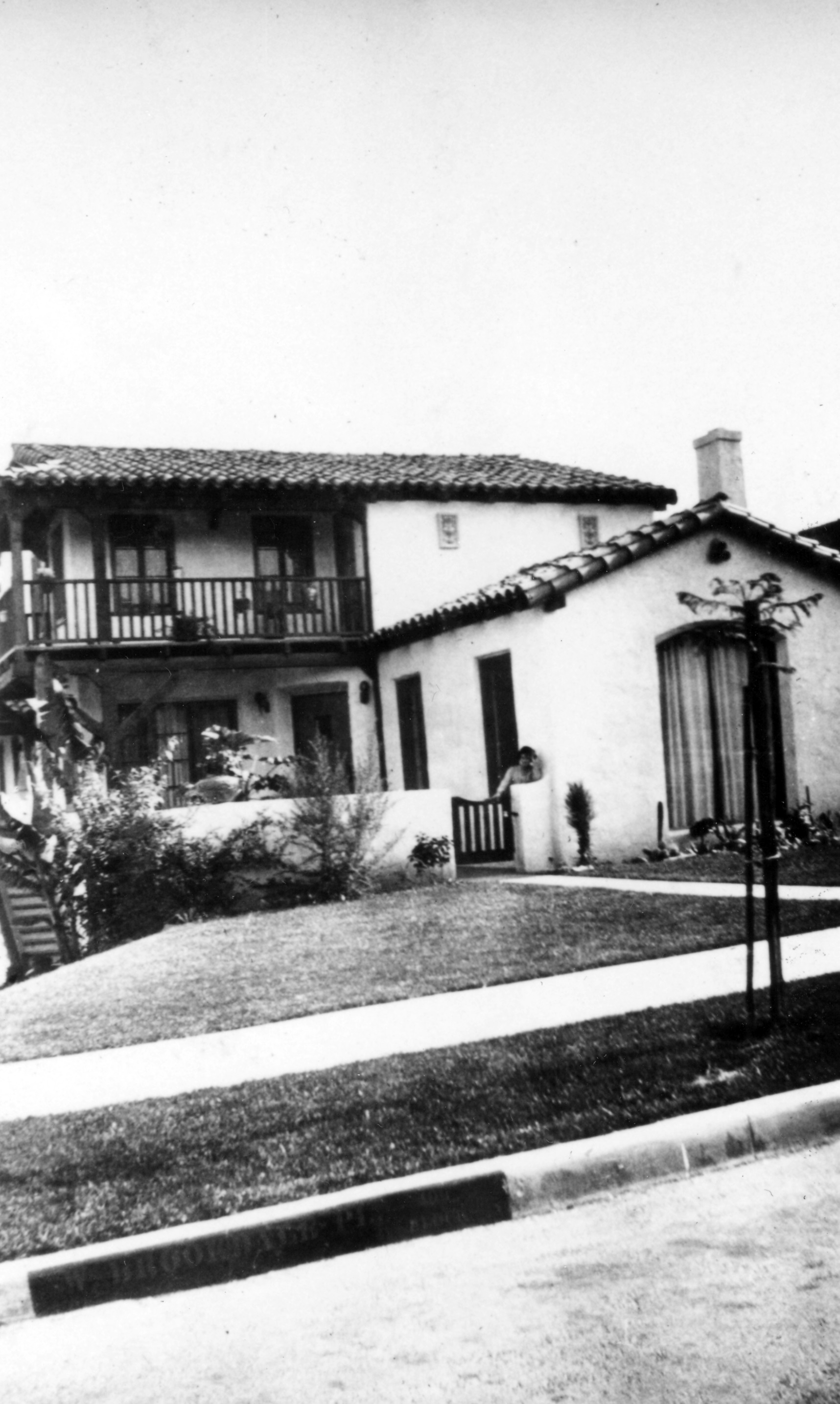 A black and white photograph of Mamie Hirigoyen on the porch of the Toney Hirigoyen House in the 1940s.