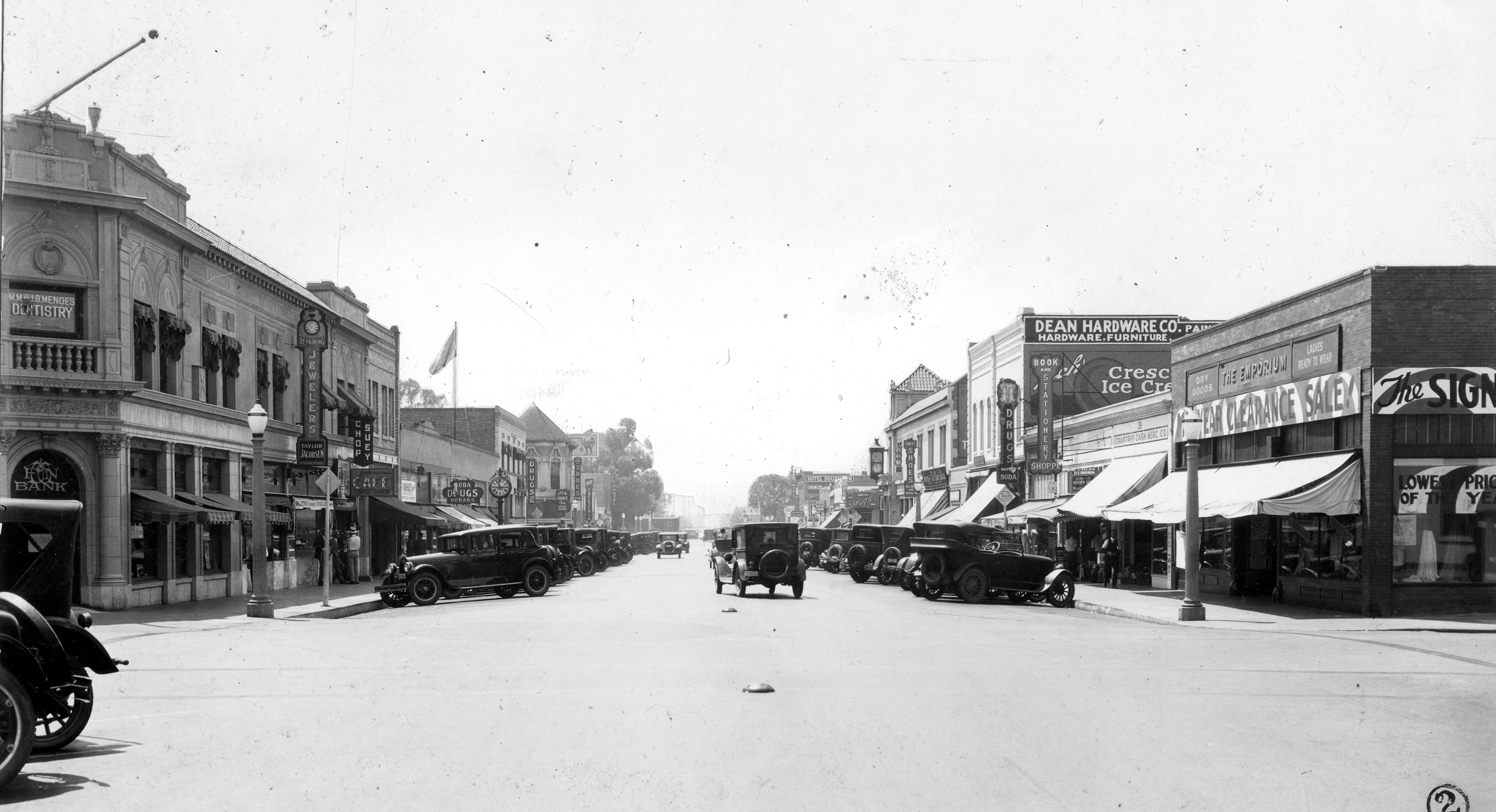 A black and white photograph of the street scene with the Stedman Jewelers&#039; Clock on the east side in the 1920s.