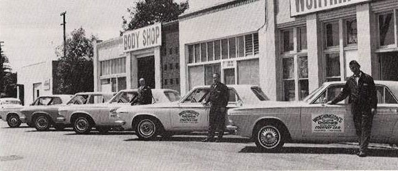 A black and white photograph of the Worthington Dodge Body Shop in 1963.
