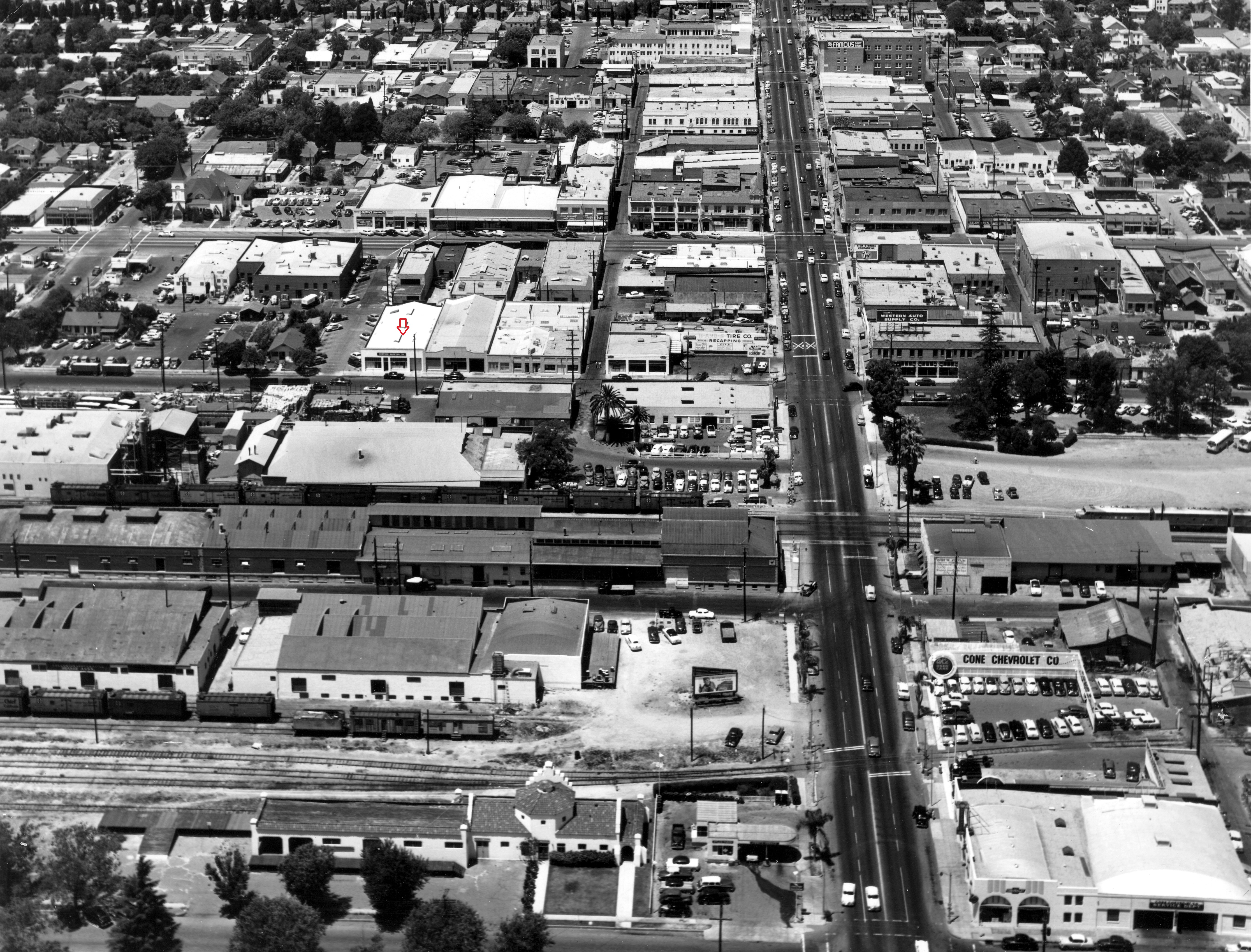 A black and white aerial view photo of the John Reeder Gardiner Building in 1953, indicated by the red arrow.