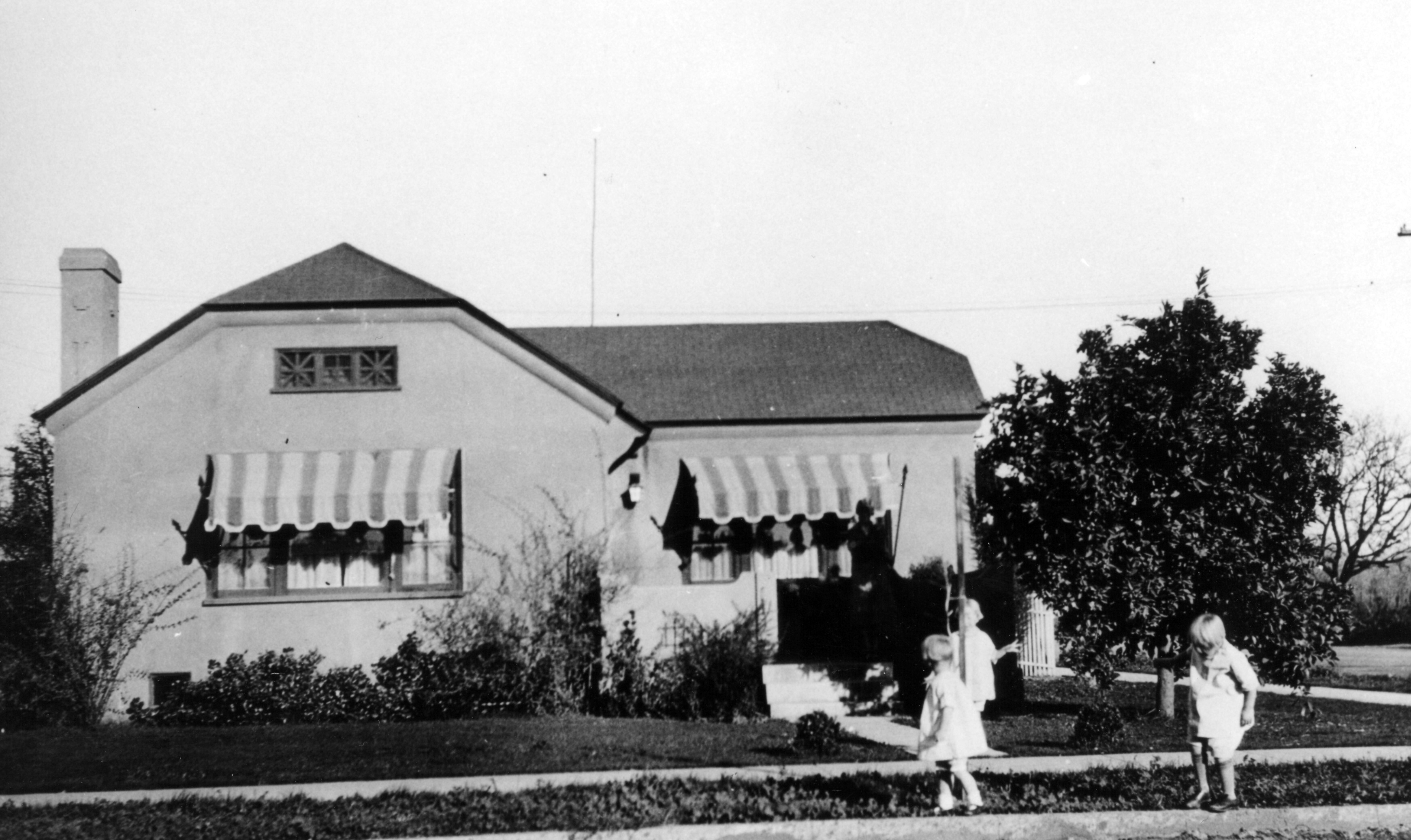 A black and white photograph of the Naylor girls in front of the James Naylor - Tom &amp; Kate Dalton House in 1928.