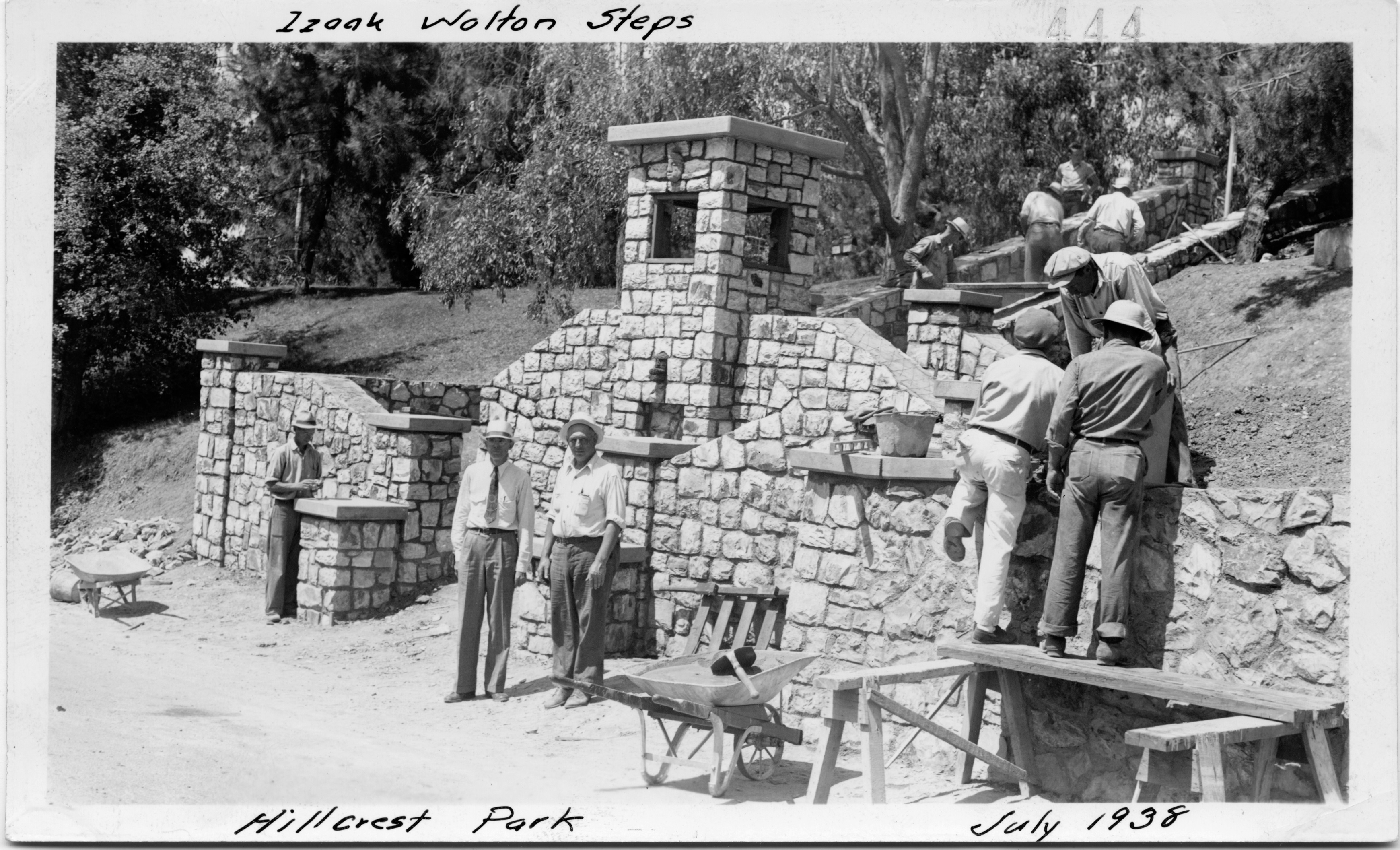 A black and white photograph of WPA workers constructing stonework at Hillcrest Park. The top of the photo reads: Izaak Walton Steps. The bottom of the photo reads: Hillcrest Park. July 1938.
