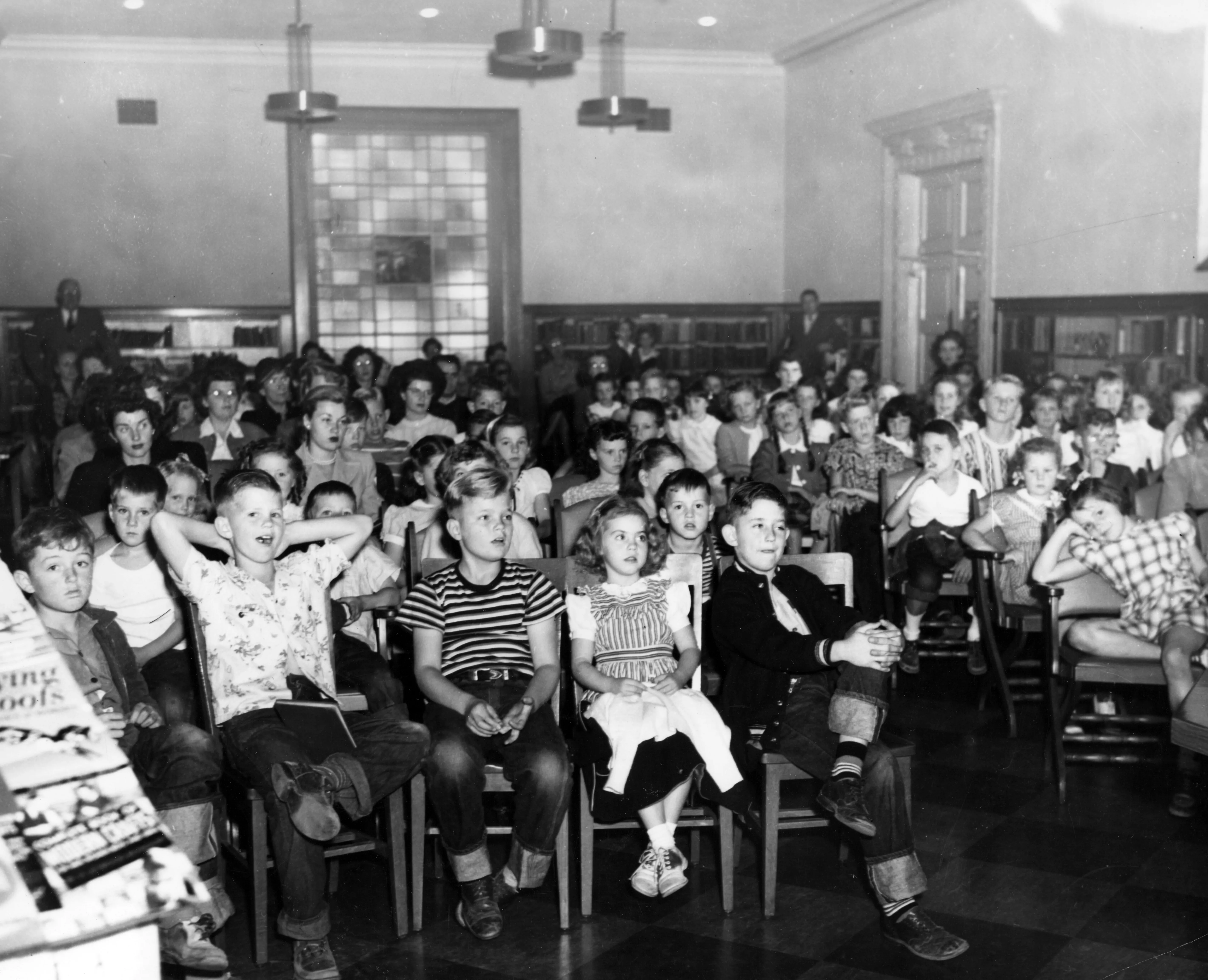 A black and white photograph of a Children&#039;s Storytime in session with a full room at Fullerton Library.