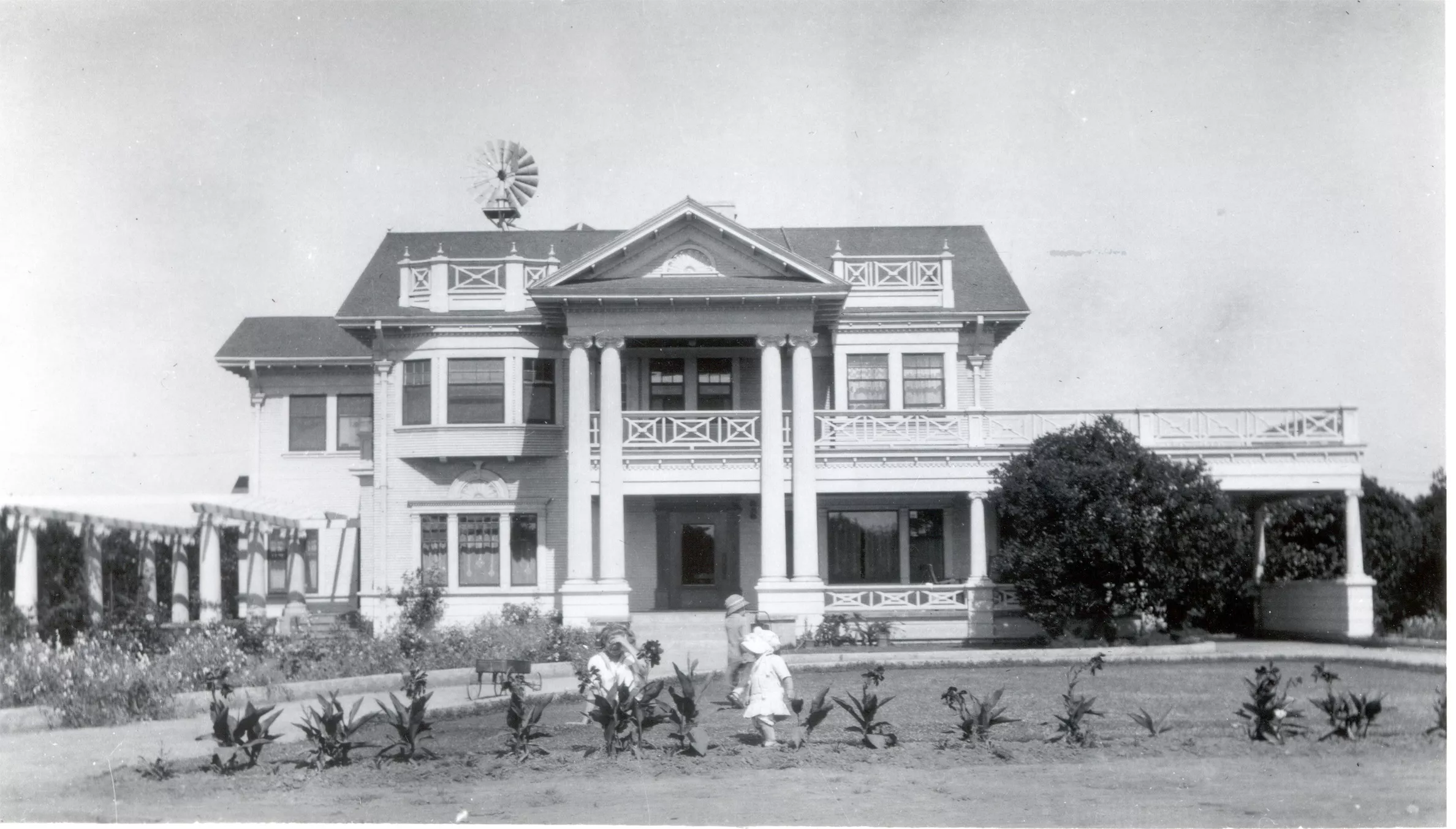A black and white photograph of the Pierotti family outside the front of the Pierotti House &amp; Gardens in 1909.