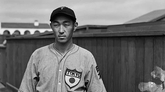 A black and white photograph of Jimmy Horio standing along a wooden fence at Amerige Park in 1935. The top of the photo, written in reverse and in cursive, reads: Jimmy Horio.