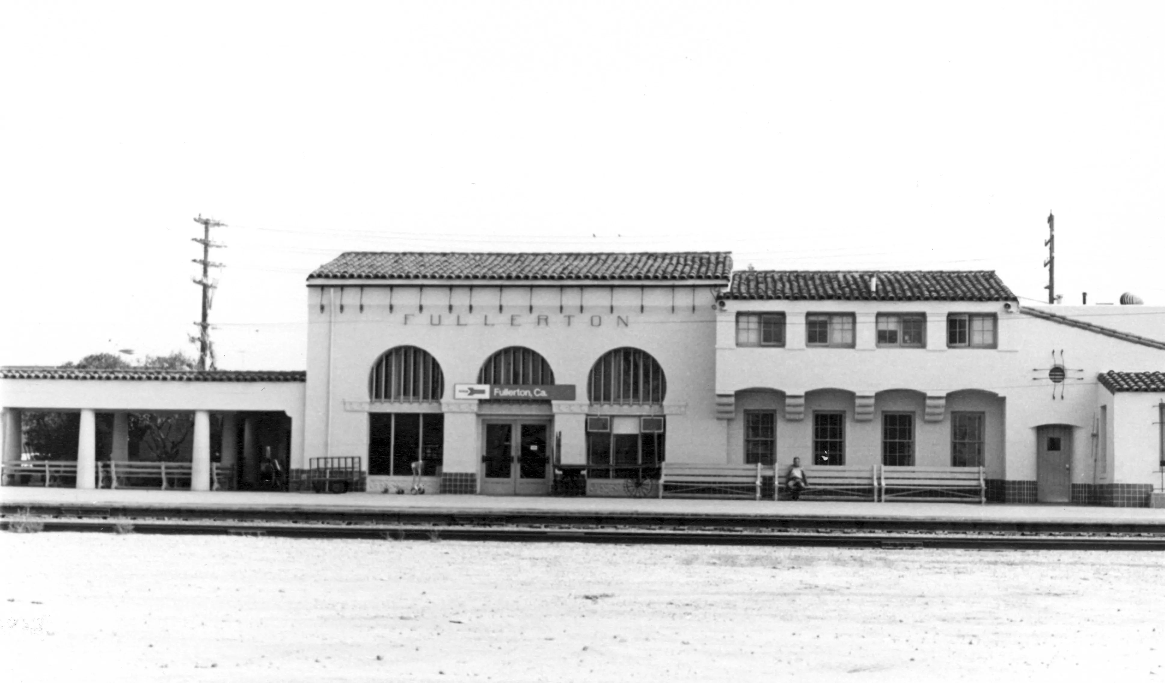 A black and white photograph of the south side of the Santa Fe Railway Passenger &amp; Freight Depot.