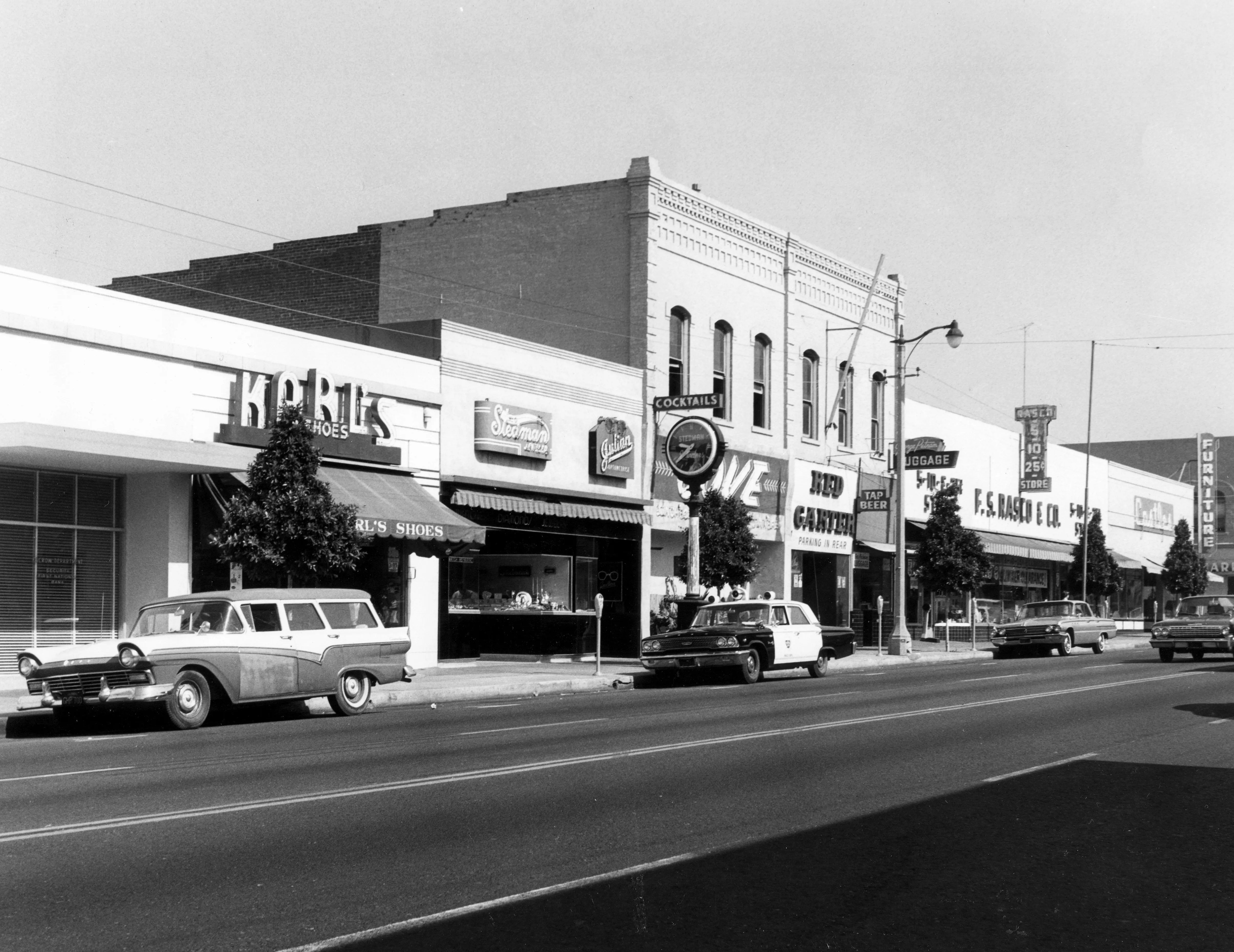 A black and white photograph of the street scene of the Dean Block in 1963.