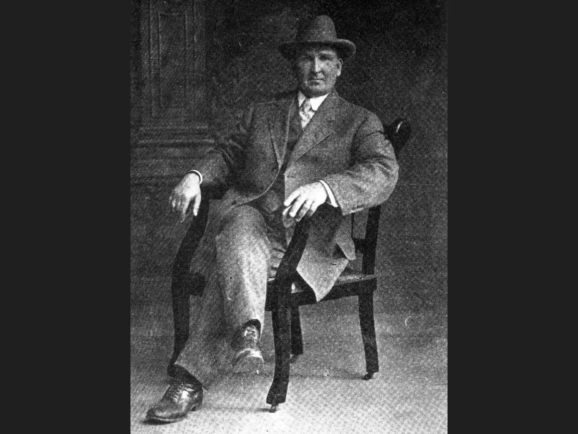 A black and white photograph of Charles Ruddock seated on a chair.