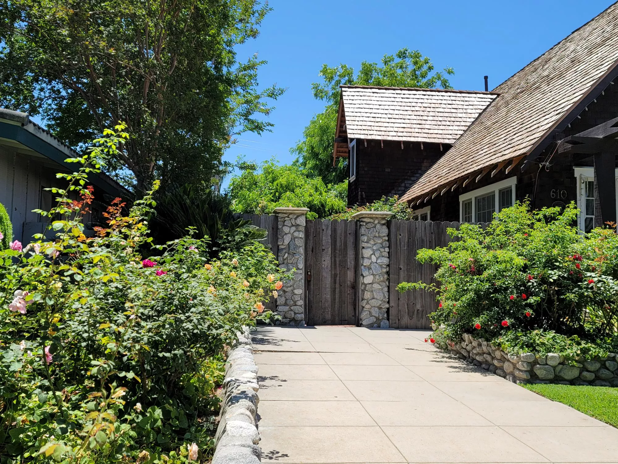 A colored photo of the east side driveway of the George Gobar House in 2024.