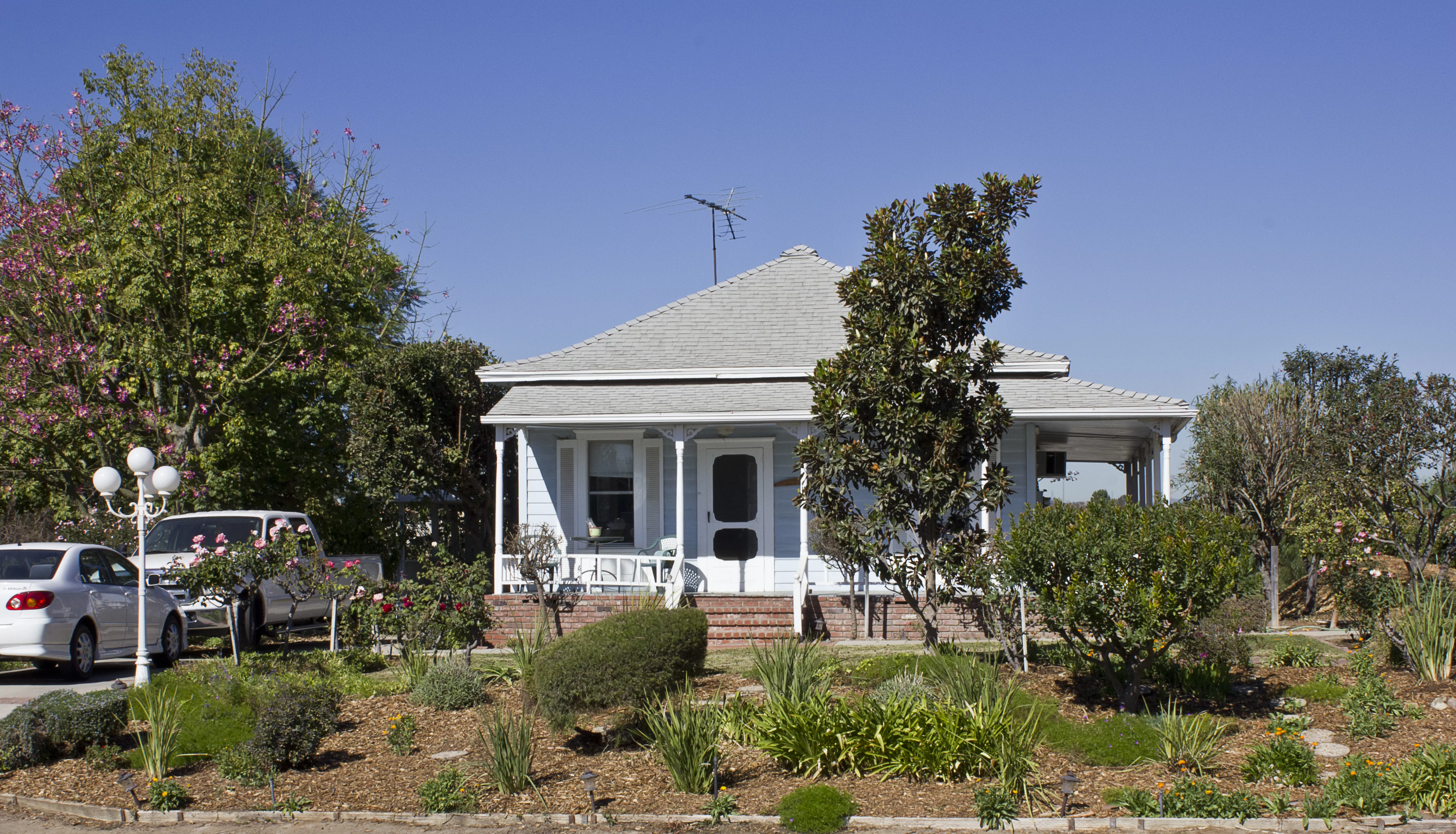 A colored photo of the front garden of the Jacob Stern Ranch/Noutary House in 2012.