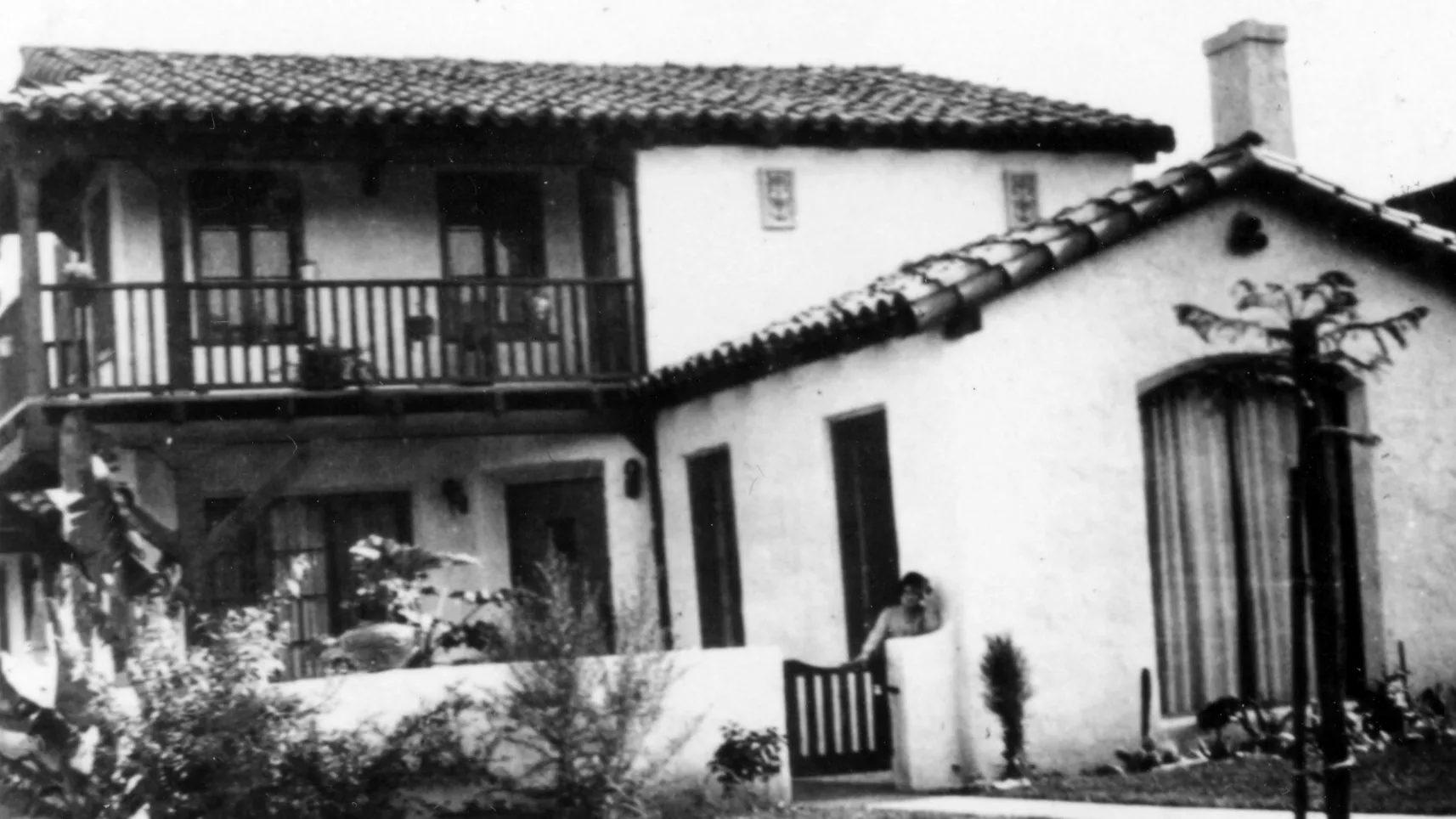 A black and white photograph of Mamie Hirigoyen on the porch of the Toney Hirigoyen House in the 1940s.