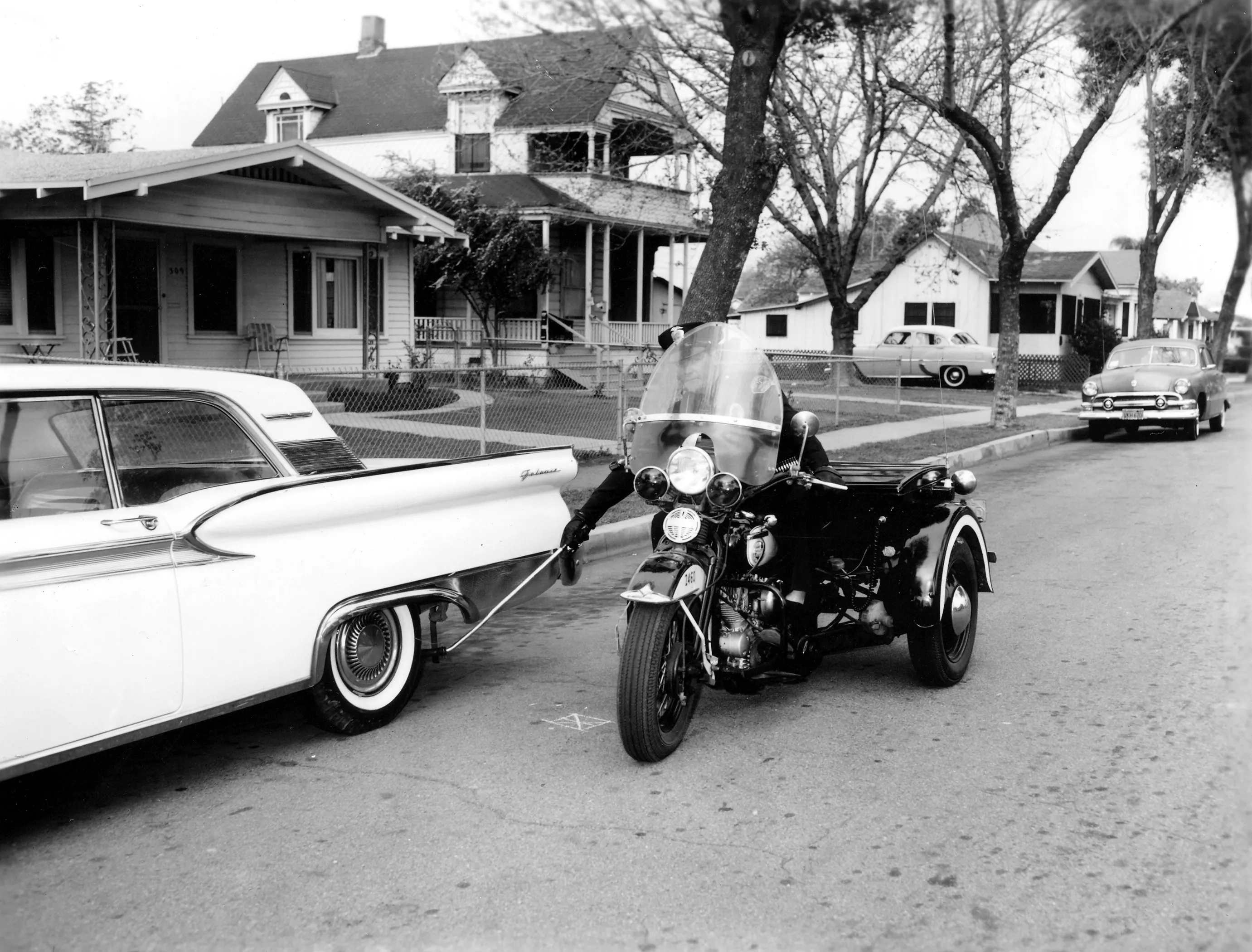 A black and white photograph of the street scene of the Wilshire Brothers/Cusick House.