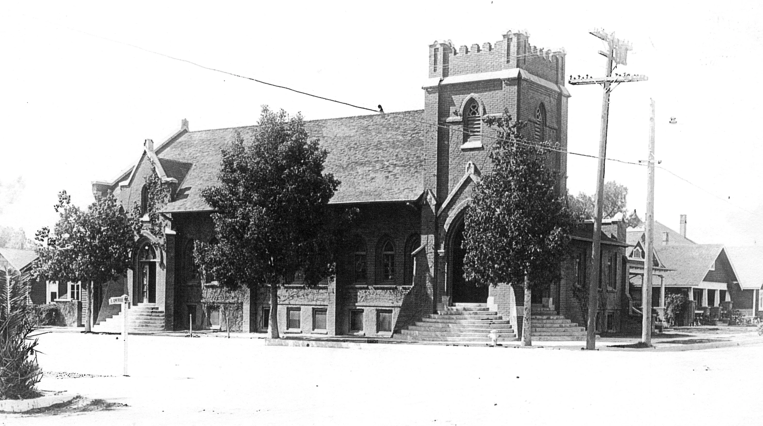 A black and white photograph of the street scene of the Fullerton First Methodist Episcopal Church.