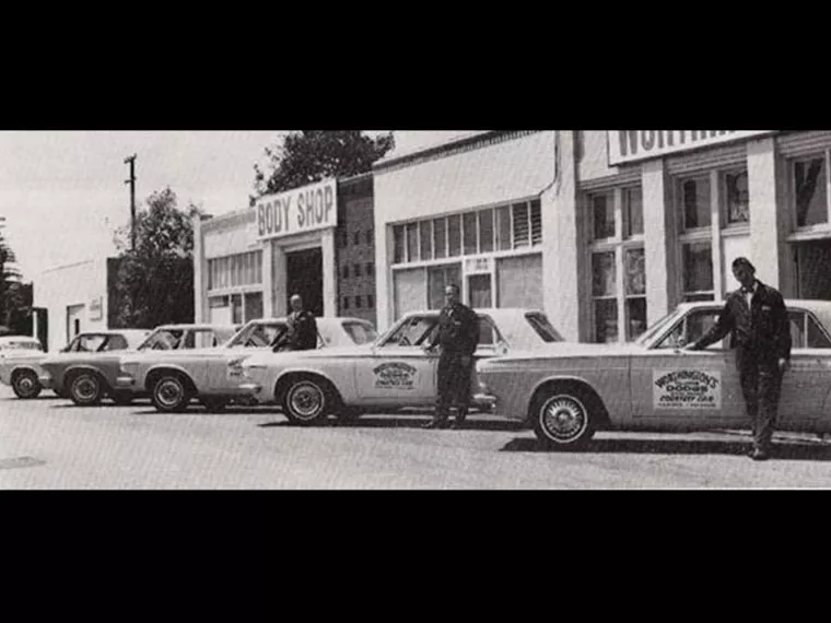 A black and white photograph of the Worthington Dodge Body Shop in 1963.