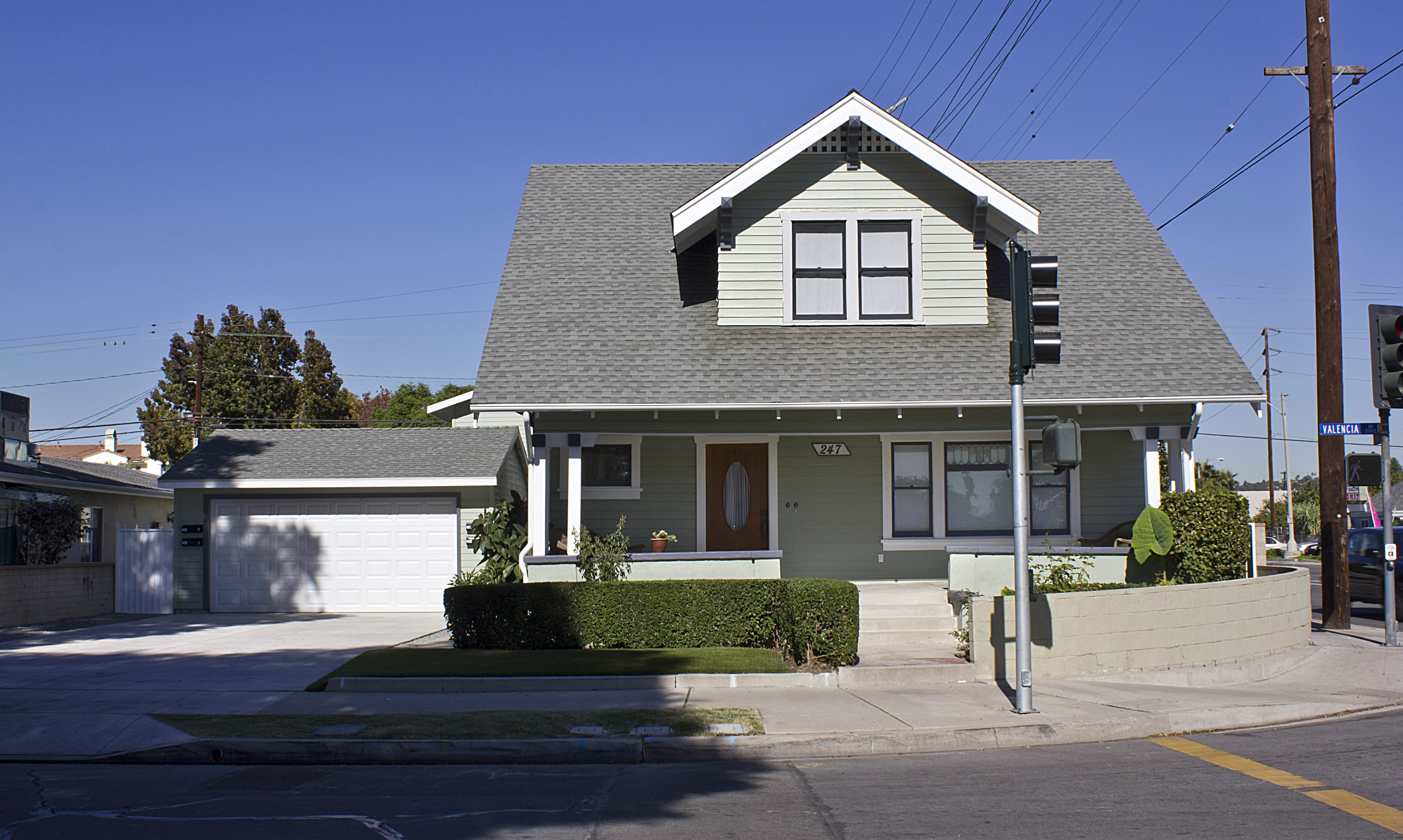 A colored photo of the front exterior with an added garage of the Henry Burdorf House in 2012.