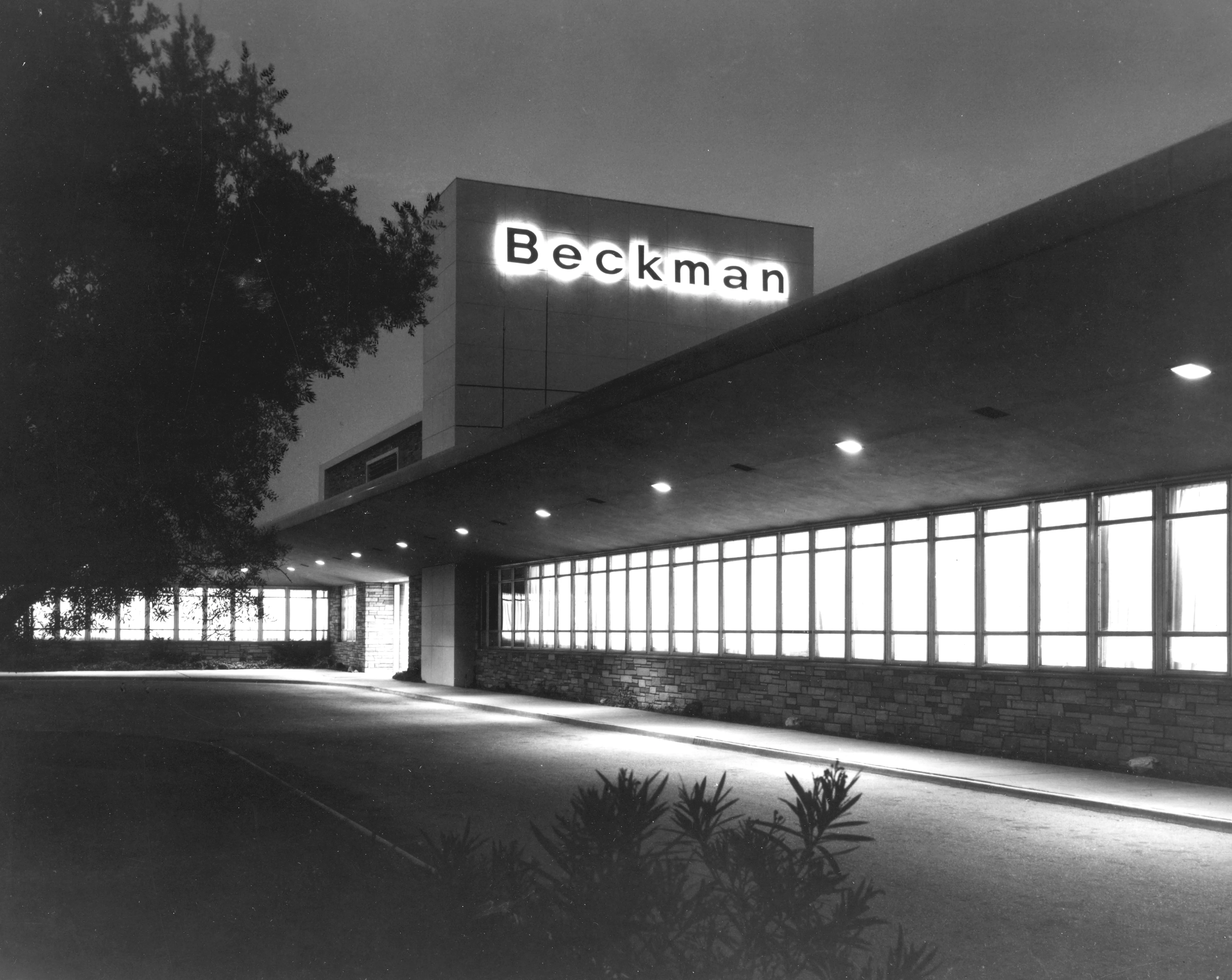 A black and white photograph of the Beckman Instruments admin offices at night.