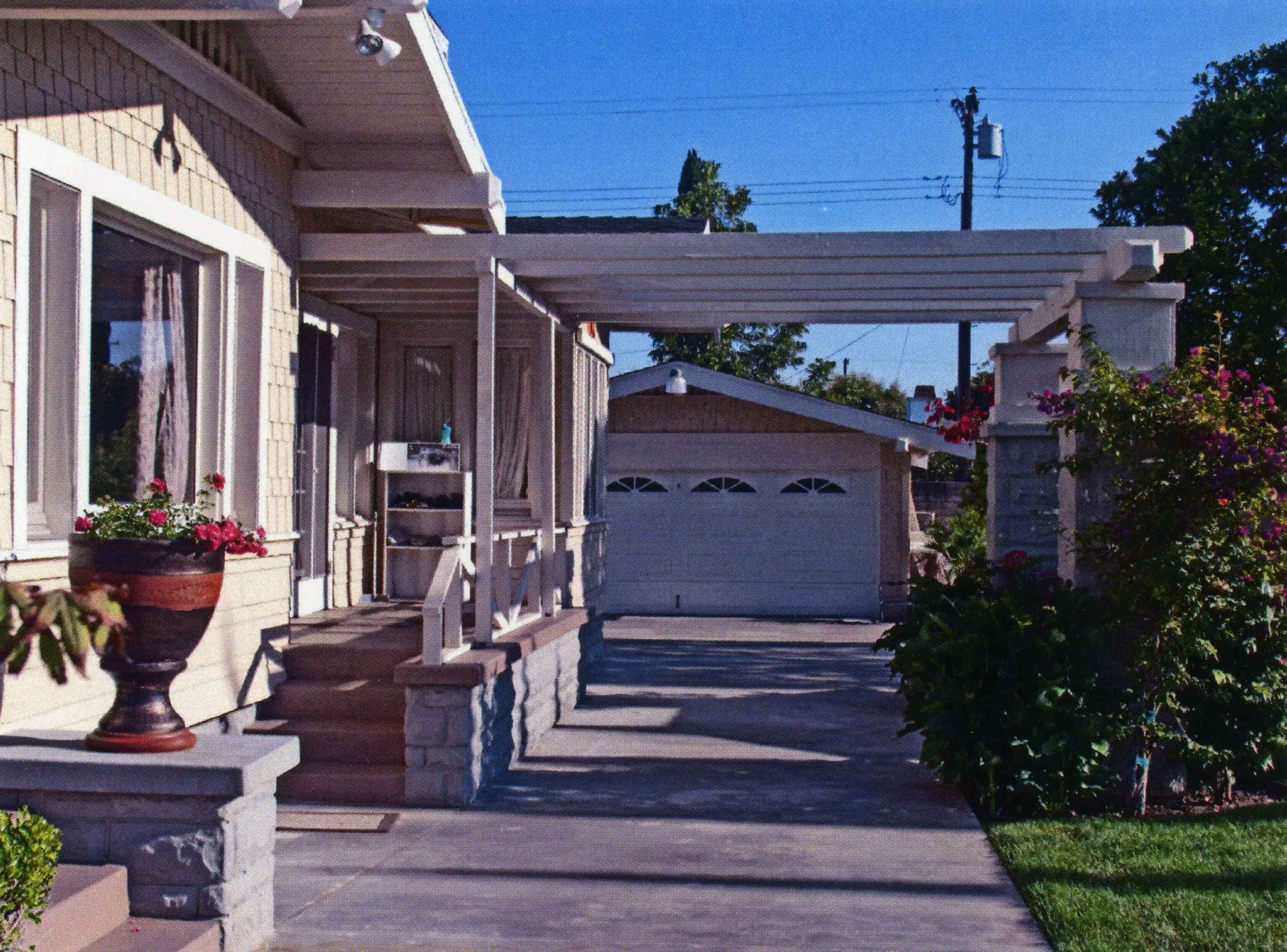 A colored photo of the driveway leading to the detached garage of the Clarence Spencer House in 2013.