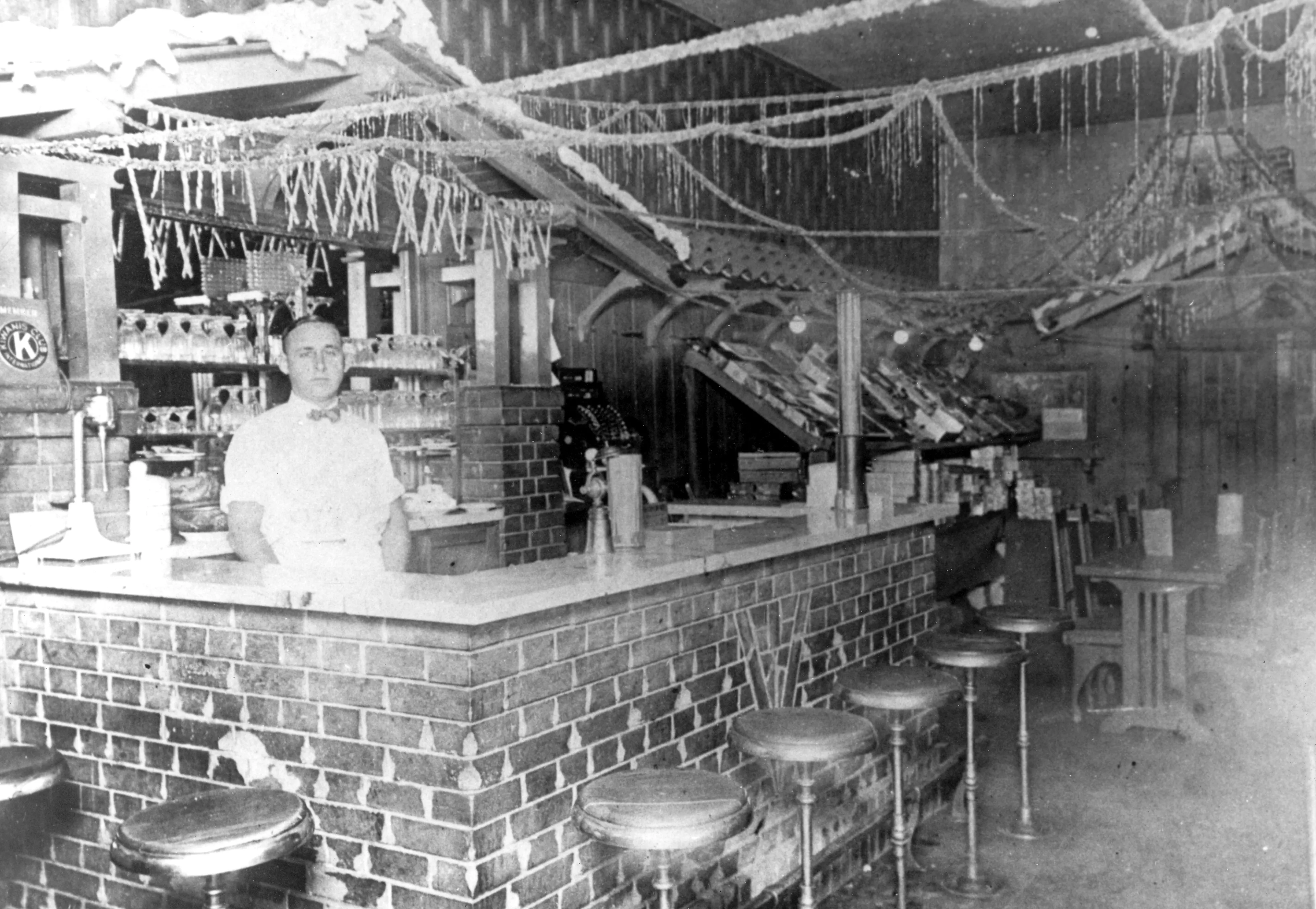 A black and white photograph of Otto Evans inside a candy store in 1914.