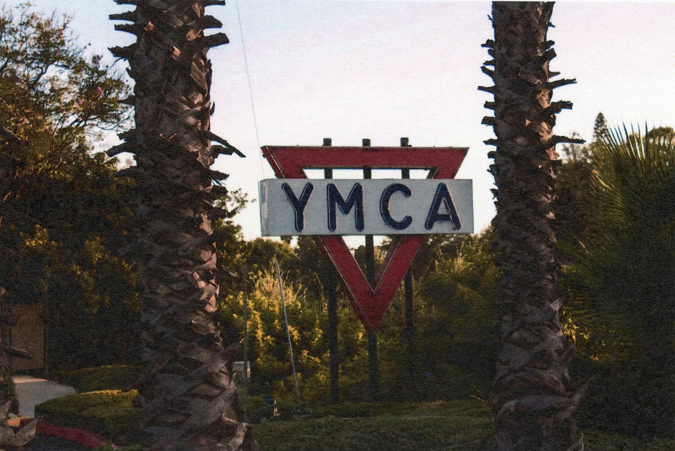 A colored photo of the YMCA Neon Sign on a hillside in 2019.