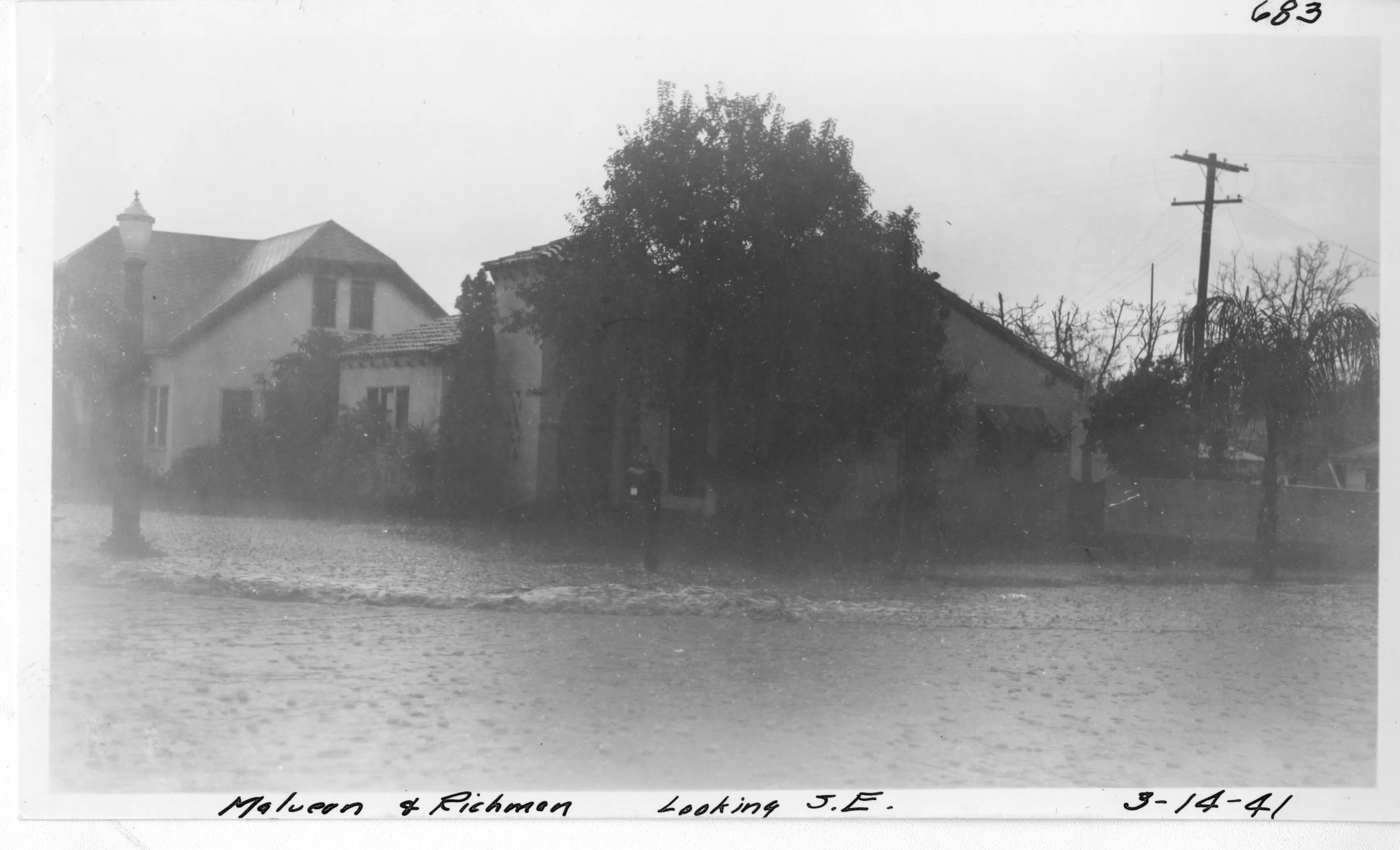 A black and white photograph of the street scene of the Earl Dysinger - Charles Schugt House during a flood in 1941. The bottom of the photo reads: Malvern and Richman. Looking southeast. March 14, 1941. The top right corner of the photo reads: 683.