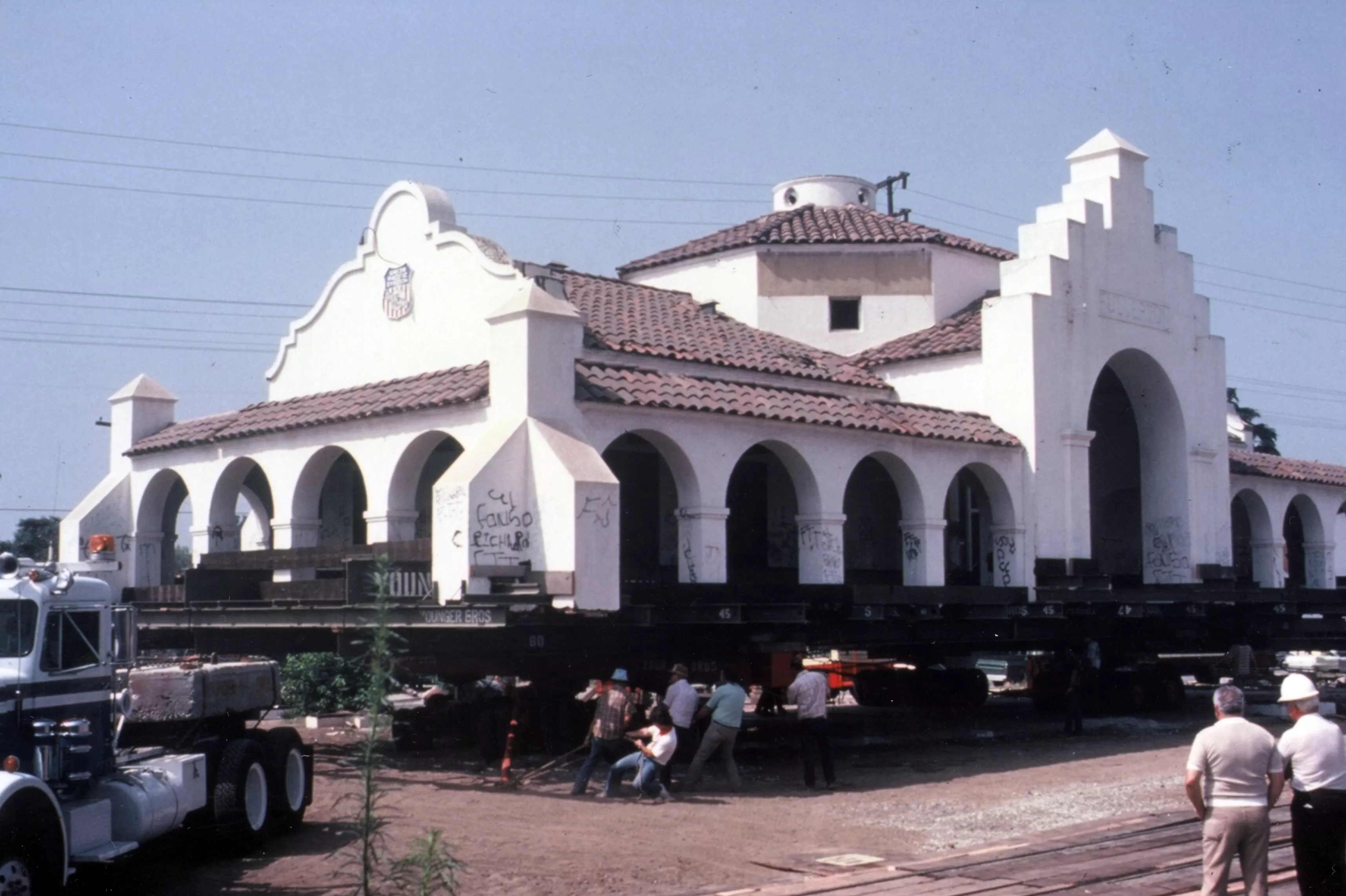 A colored photo of workers moving the Union Pacific Depot in 1980.