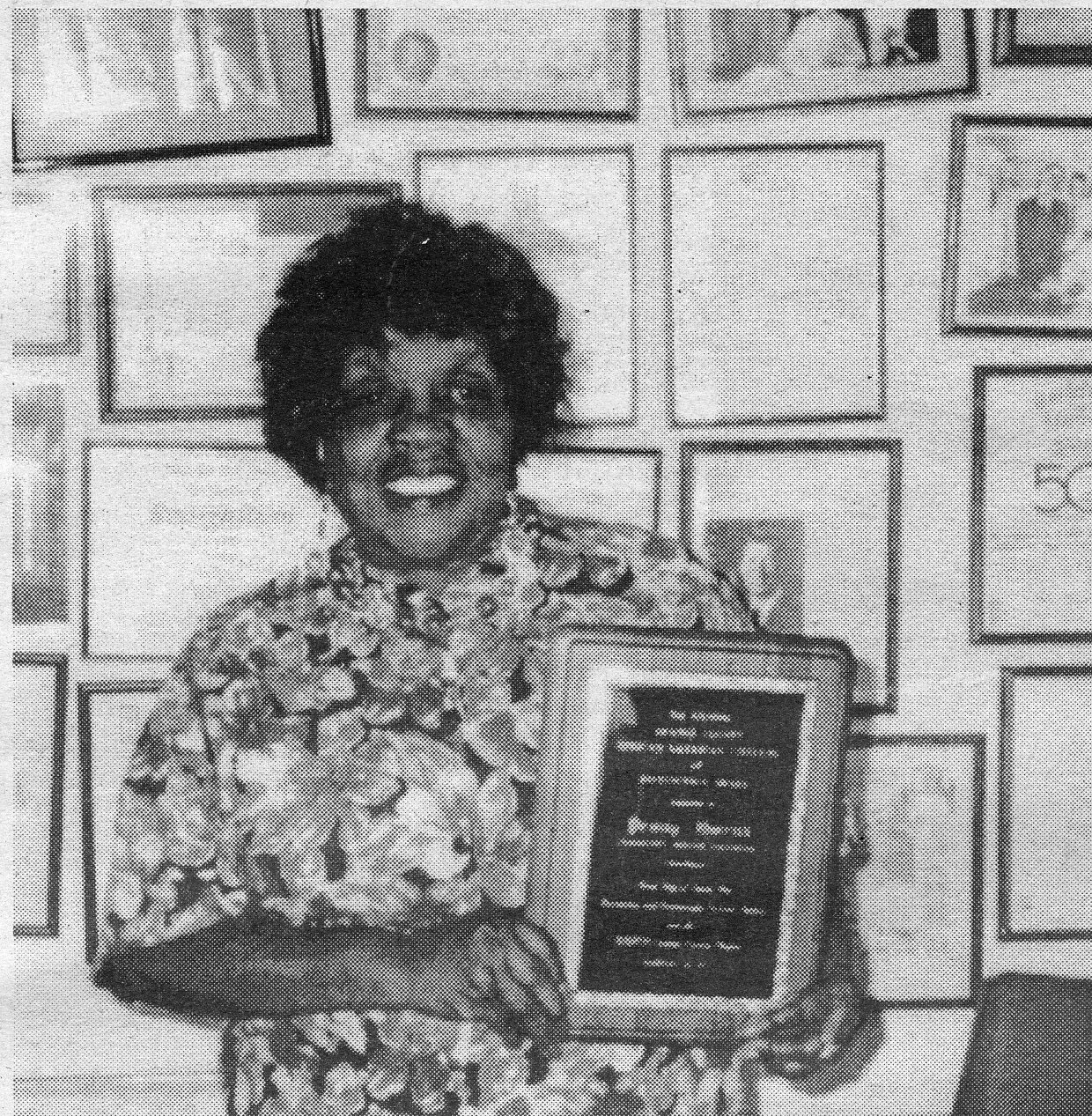 An image of Penny Owens holding a plaque.
