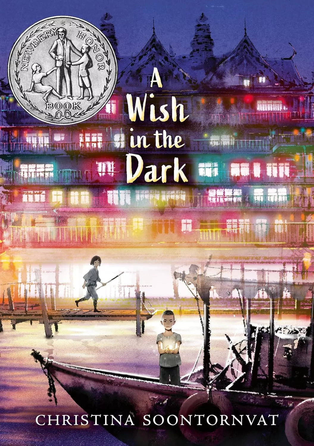 Cover of A Wish in the Dark by Christina Soontornvat depicting a boy on a boat in the foreground and a girl standing on the dock behind him. There is a large city in the background.